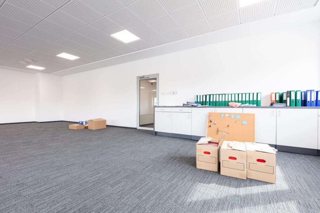 Empty office with cardboard boxes and documents ready for moving