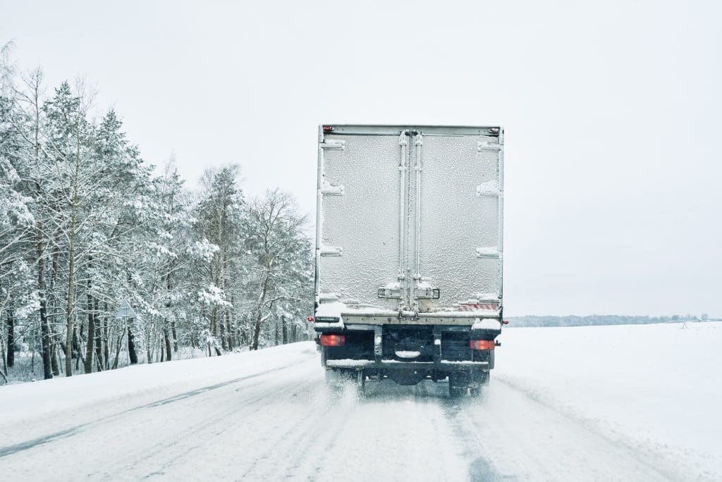 Moving truck driving down winter road