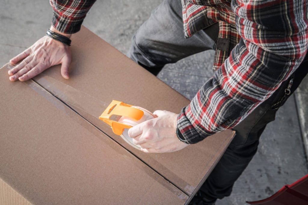 Employee taping box as part of Full-Service Packing by The Moving Guys.