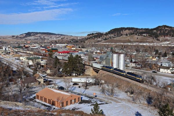 Wide shot of a train moving through snowy Sturgis, South Dakota